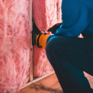professional installing insulation in wall
