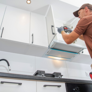 professional installing white kitchen cabinets above a sink